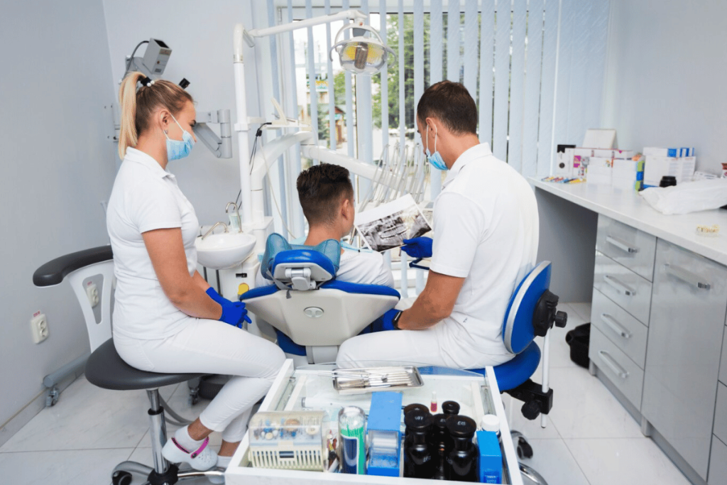 Three people sitting in a dental chair.