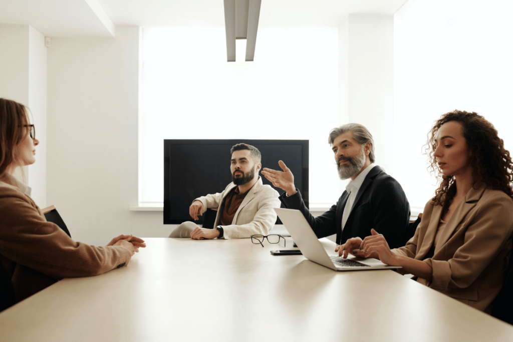 Business team in a conference room with a man gesturing during a discussion.