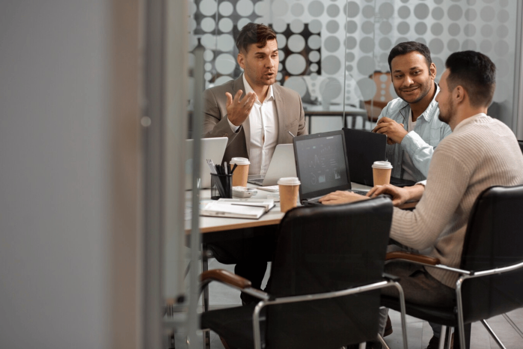 Three people in active discussion in a modern office.