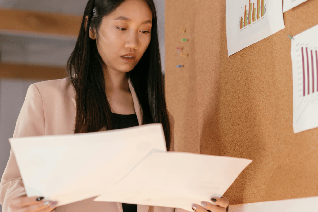 Businesswoman holding charts with data analysis.