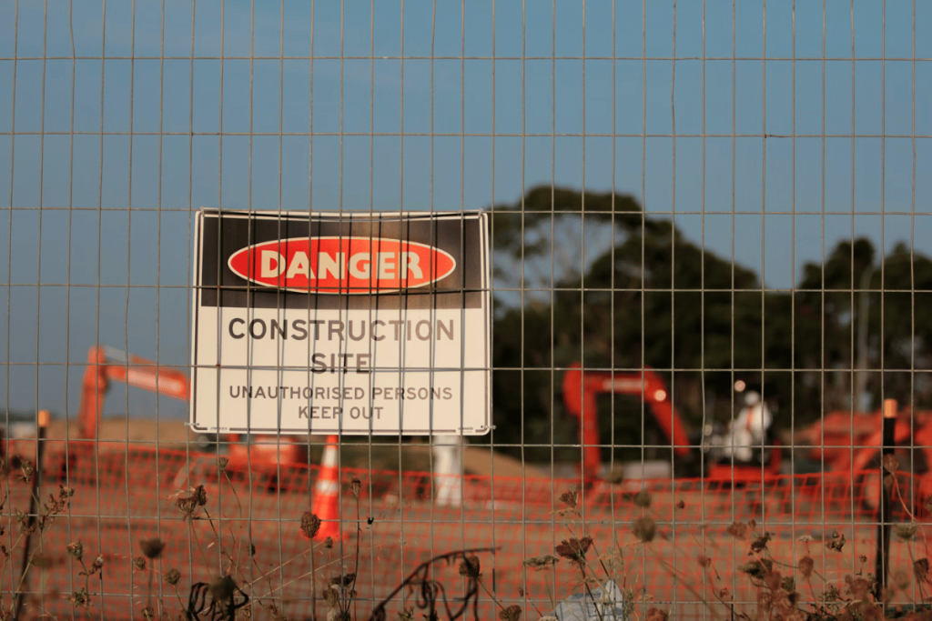 A fence with a sign on it that says "danger construction safe".